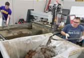 Image of people removing solids from waterjet