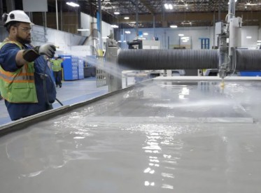 Image of worker spraying a waterjet table
